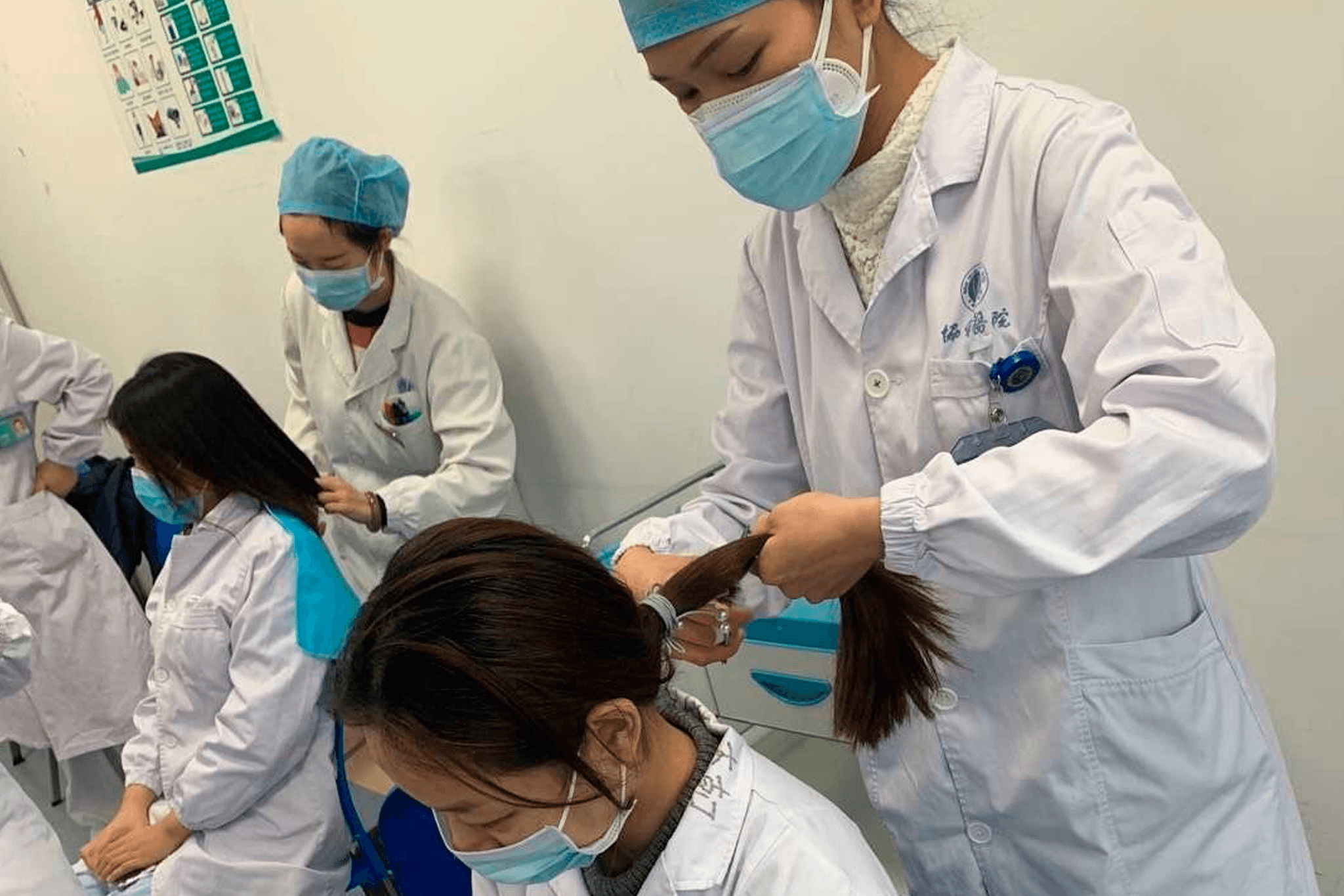 Krankenpflegerinnen aus verschiedenen Regionen Chinas kürzen sich vor dem Einsatz in Wuhan gegenseitig die Haare.
