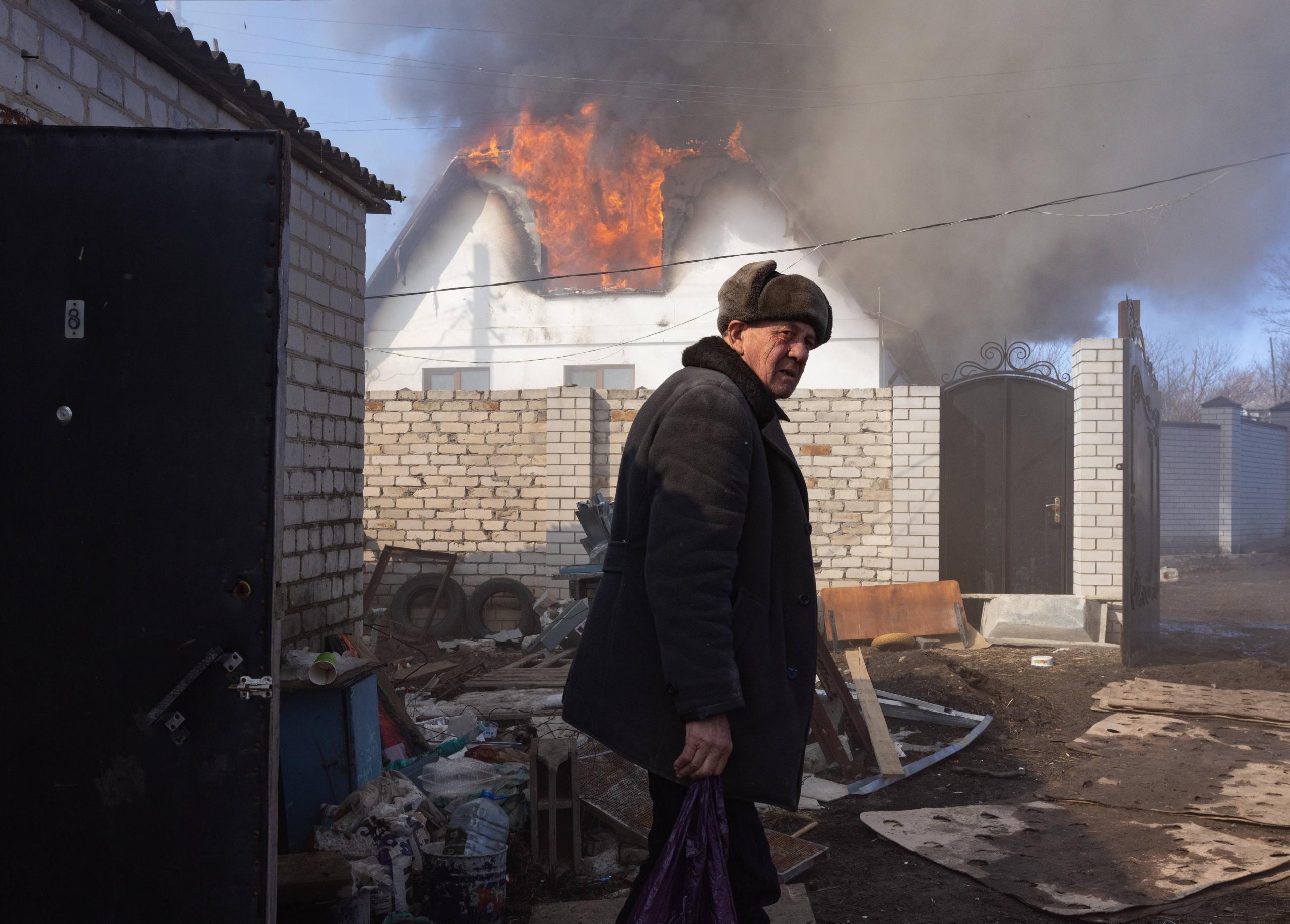 Bewohner des Dorfes Warwariwka in Luhansk vor von Bomben zerstörten Wohnhäusern, 21. März 2022.