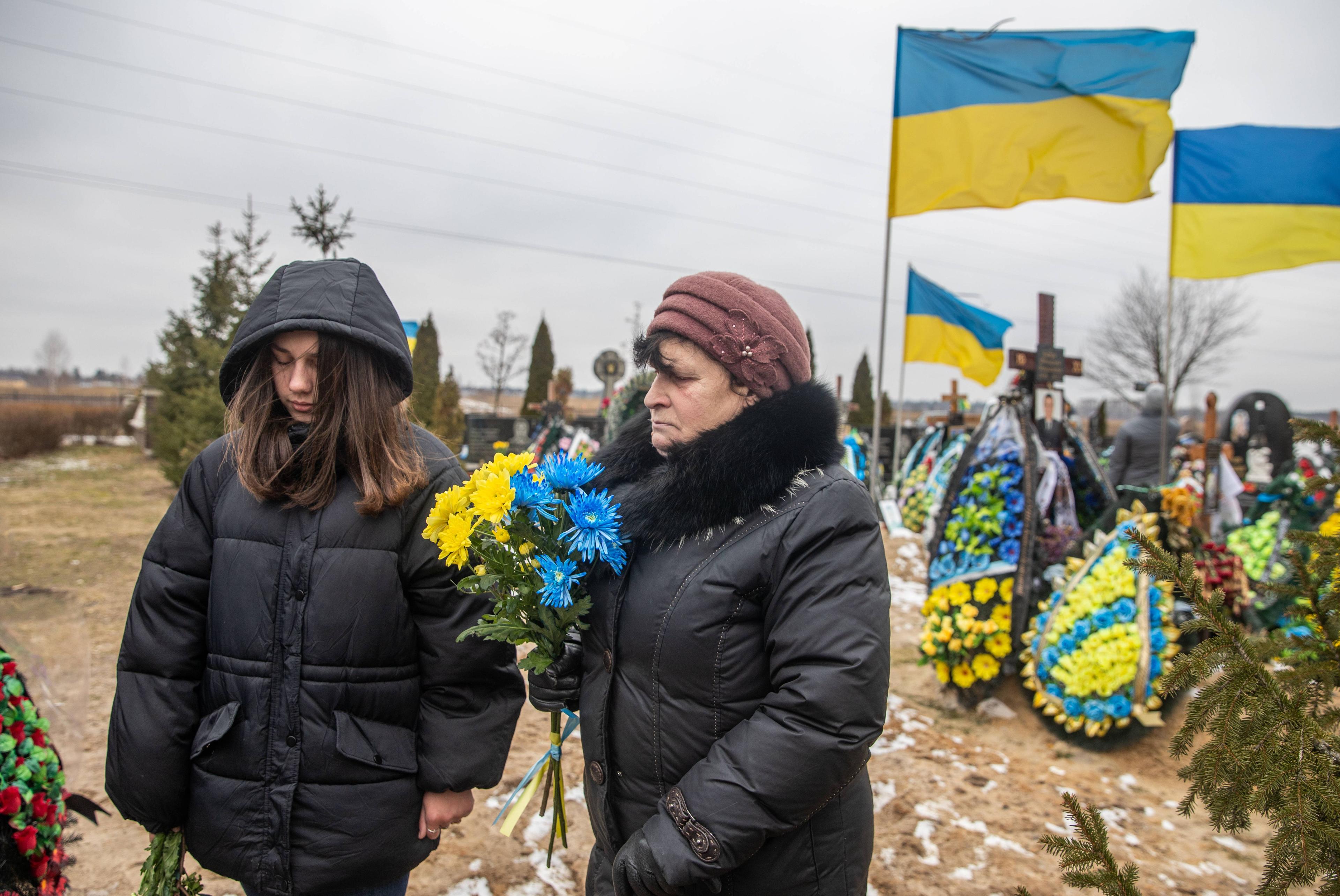 Ein Jahr nach der Invasion gedenken Angehörige der Opfer des Ukraine-Kriegs auf einem Friedhof in Butscha, 24. Februar 2023.