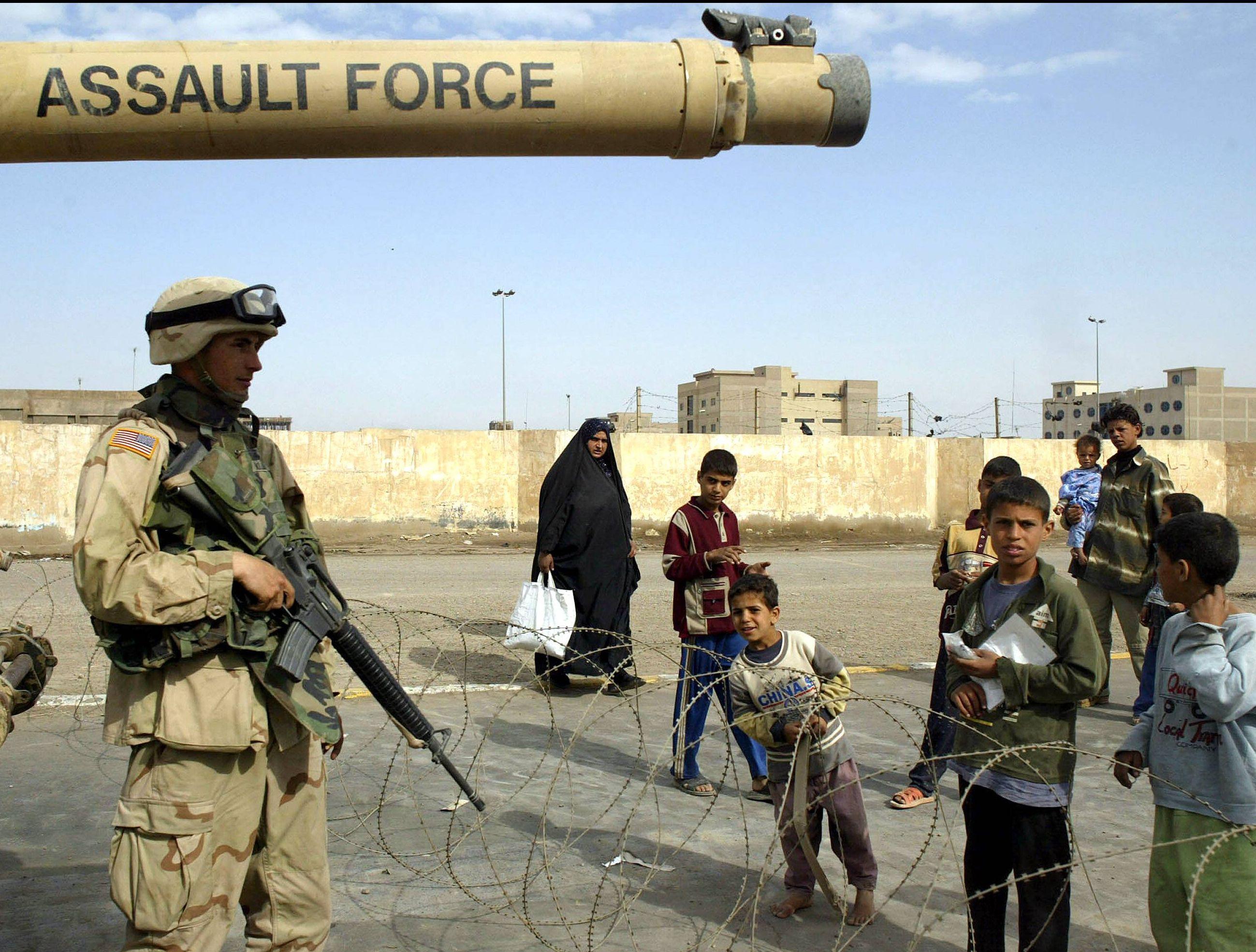 US-Soldat neben irakischen Kindern im Stadtteil Sadr, Bagdad, 2004.