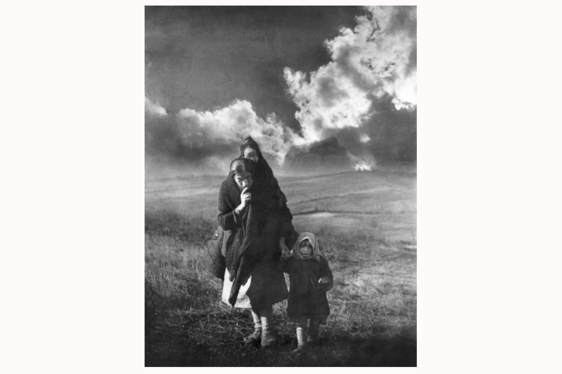 Mutter Knežopoljka. Fotografiert von Žorž Skrigin im Dorf Knežpolje, Kozara, Bosnien und Herzegowina, während der Sechsten-Feind-Offensive, Januar 1944. (Mit freundlicher Genehmigung des Museums der Geschichte Jugoslawiens, III-807). Dieses ikonische Foto wurde von Žorž Skrigin Ende 1943 aufgenommen. Es zeigt Milica Tepic, Mutter und Ehefrau des gefallenen Nationalhelden Branko Tepic, mit ihrem Sohn Branko und ihrer Tochter Dragica. Der kroatische Kunsthistoriker und Kurator Želimir Koščević verglich das Bild mit der bekannten Fotografie »Heimatlose Mutter« von Dorothea Lange aus dem Jahr 1936. Hinter der jungen Mutter und Witwe bricht die gleißende Wintersonne nur teilweise durch die dunklen Wolken, die Skrigin im Fotolabor nachträglich aufhellte, um den Kontrast und die Dramatik des abgebildeten Ereignisses zu unterstreichen. Die Bedingungen, unter denen dieses Foto entstand, sind mit denen der alliierten und deutschen Fotografen kaum vergleichbar. Dennoch schaffte Skrigin eine Fotografie, die mit der Zeit an Wert gewann. Sie zählt zu den bekanntesten Arbeiten Skrigins. Die Umsetzung von in der Kunstgeschichte anerkannten Elementen zeugt von Skrigins umfassenden fotografischen Erfahrungen aus der Vorkriegszeit. Diese Fotografie ist ein treffendes Beispiel dafür, wie durch die Fotografie Botschaften und Inhalte verbreitet werden können – in diesem Fall das Leid der Zivilbevölkerung, die Schrecken des Krieges, aber auch die heroischen Leistungen, die durch die stereotype Figur der Mutter symbolisiert werden.