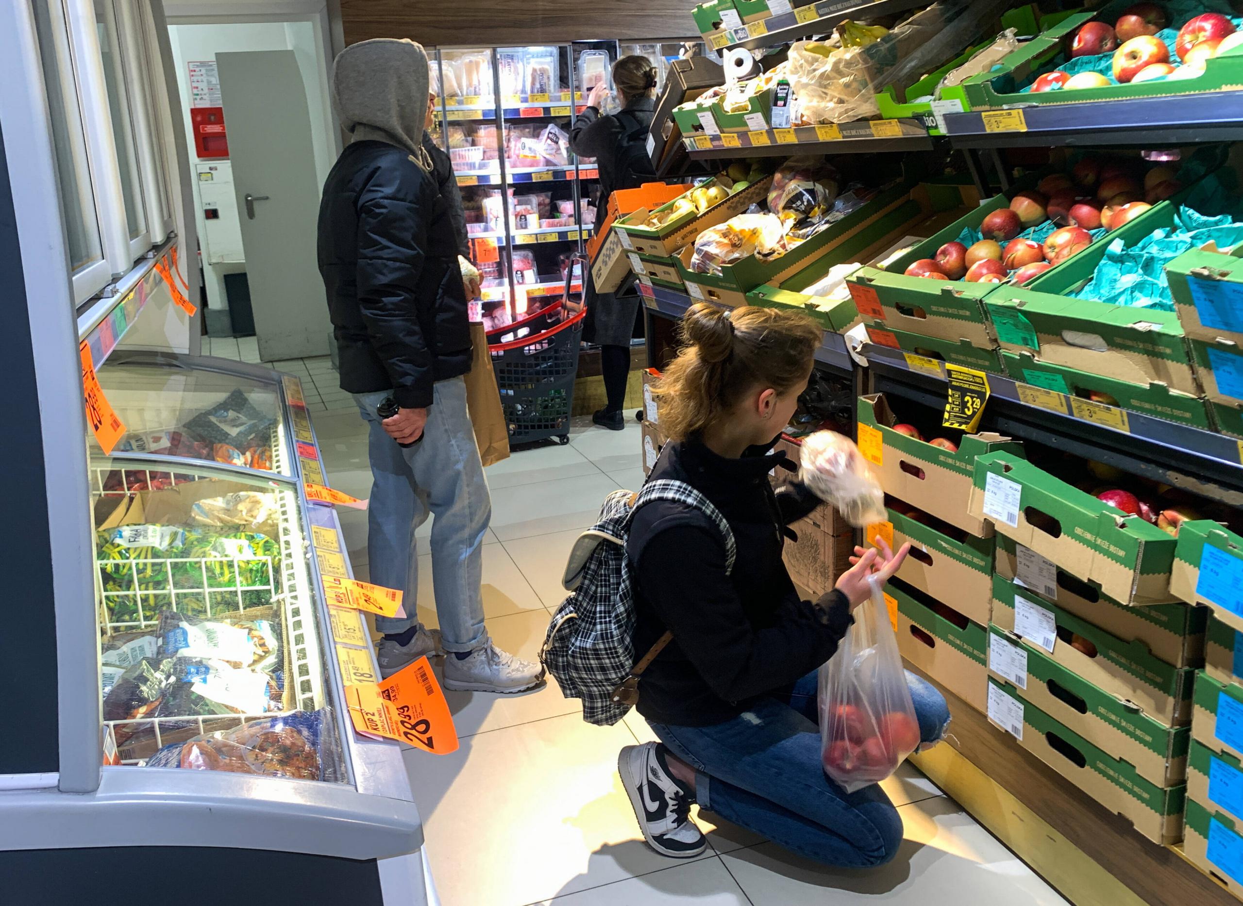Kundinnen und Kunden in einem Supermarkt in Kraków, Polen.
