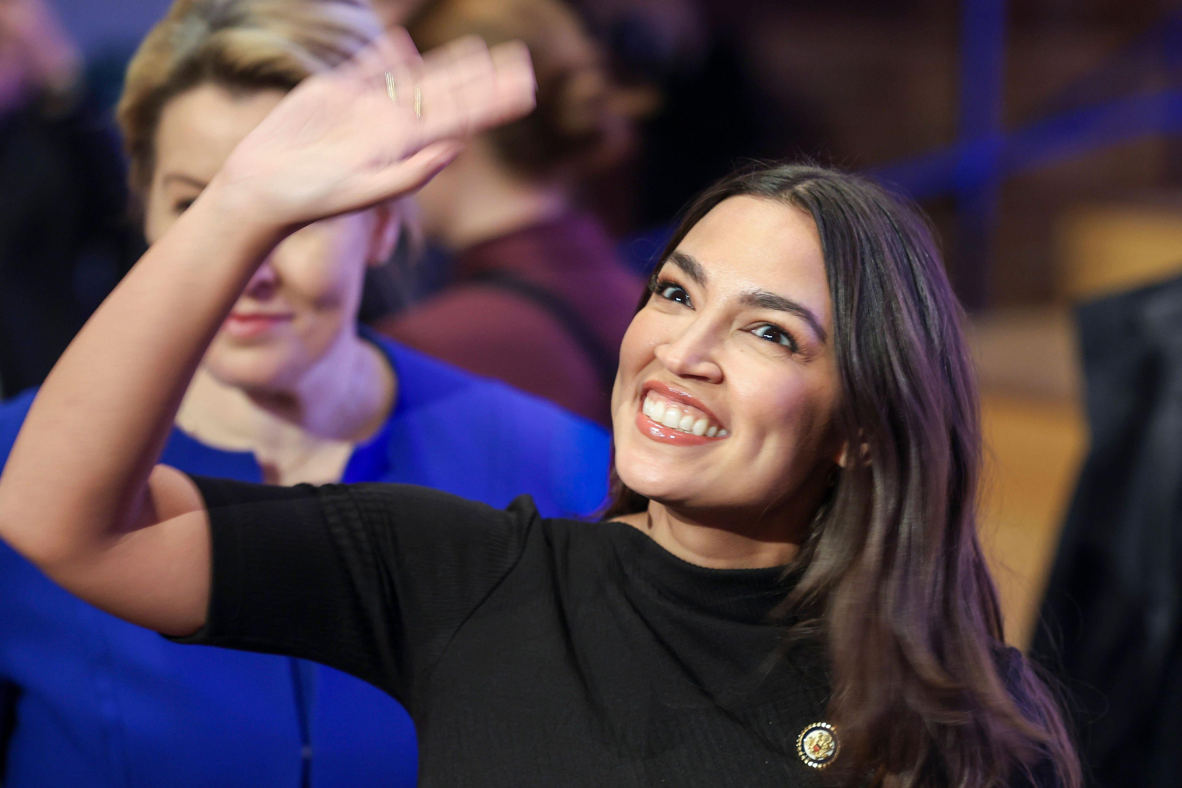 Alexandria Ocasio-Cortez winkt dem Publikum zu bei ihrem Auftritt in Berlin; hinter ihr eine sichtlich berührte Franziska Giffey.