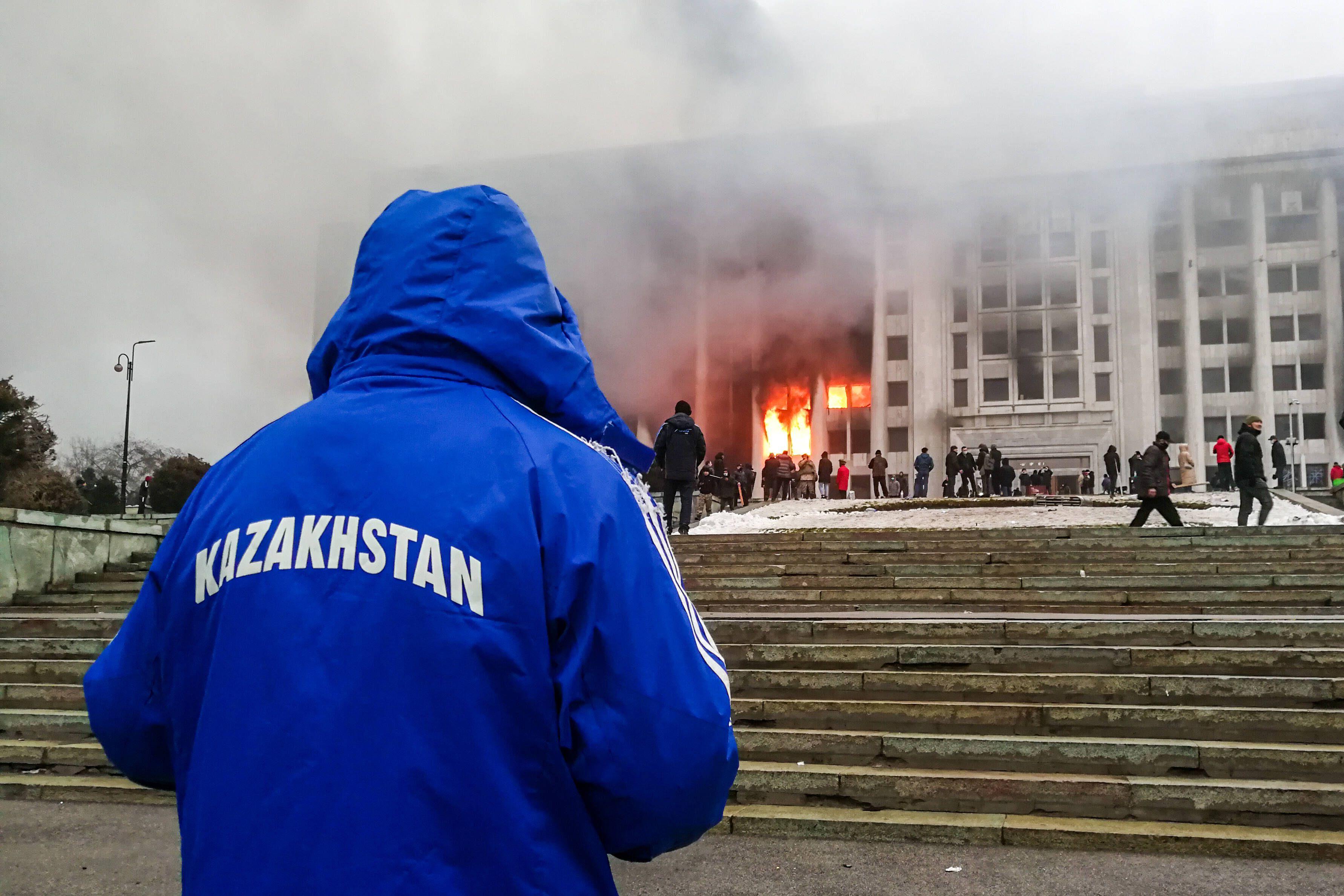 Demonstrierende protestieren vor der ausgebrannten Stadtverwaltung in Almaty, Kasachstan, 5. Januar 2022.