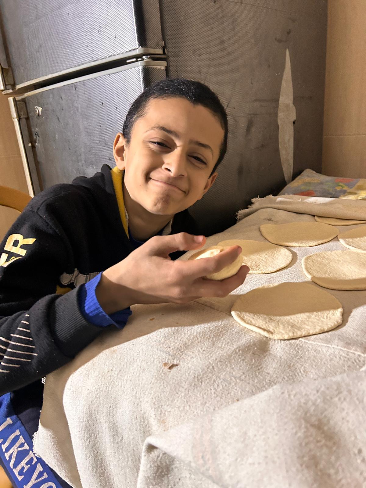 Malaks Bruder Achmed freut sich auf frisches Brot aus richtigem Mehl. Zuvor mussten sie Brot aus Tierfutter herstellen.