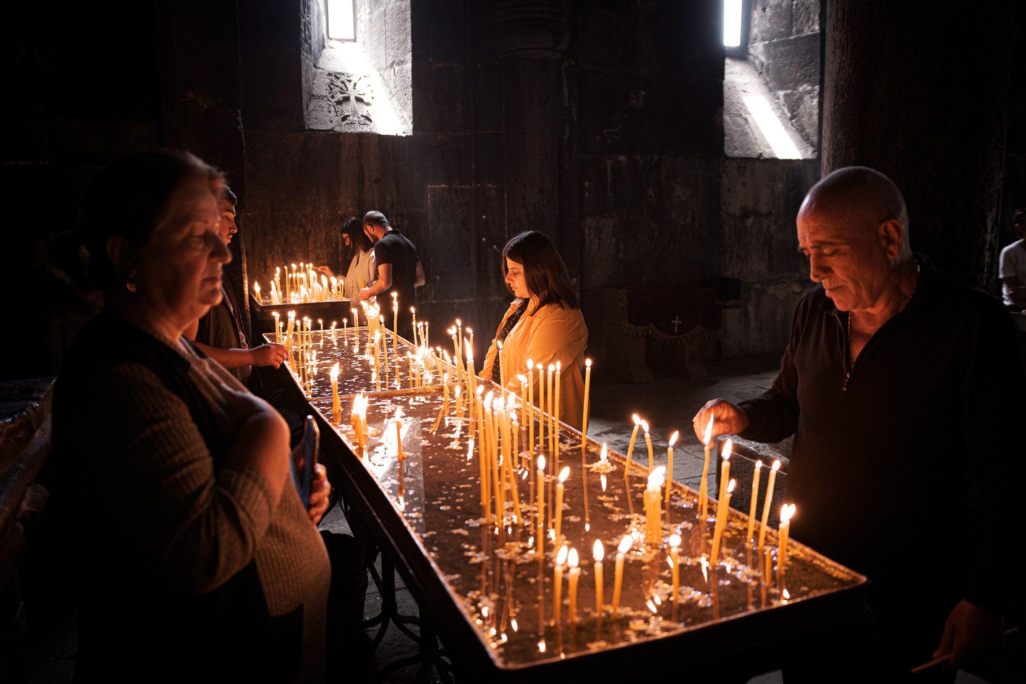 Armenierinnen und Armenier beten im Kloster Geghard.