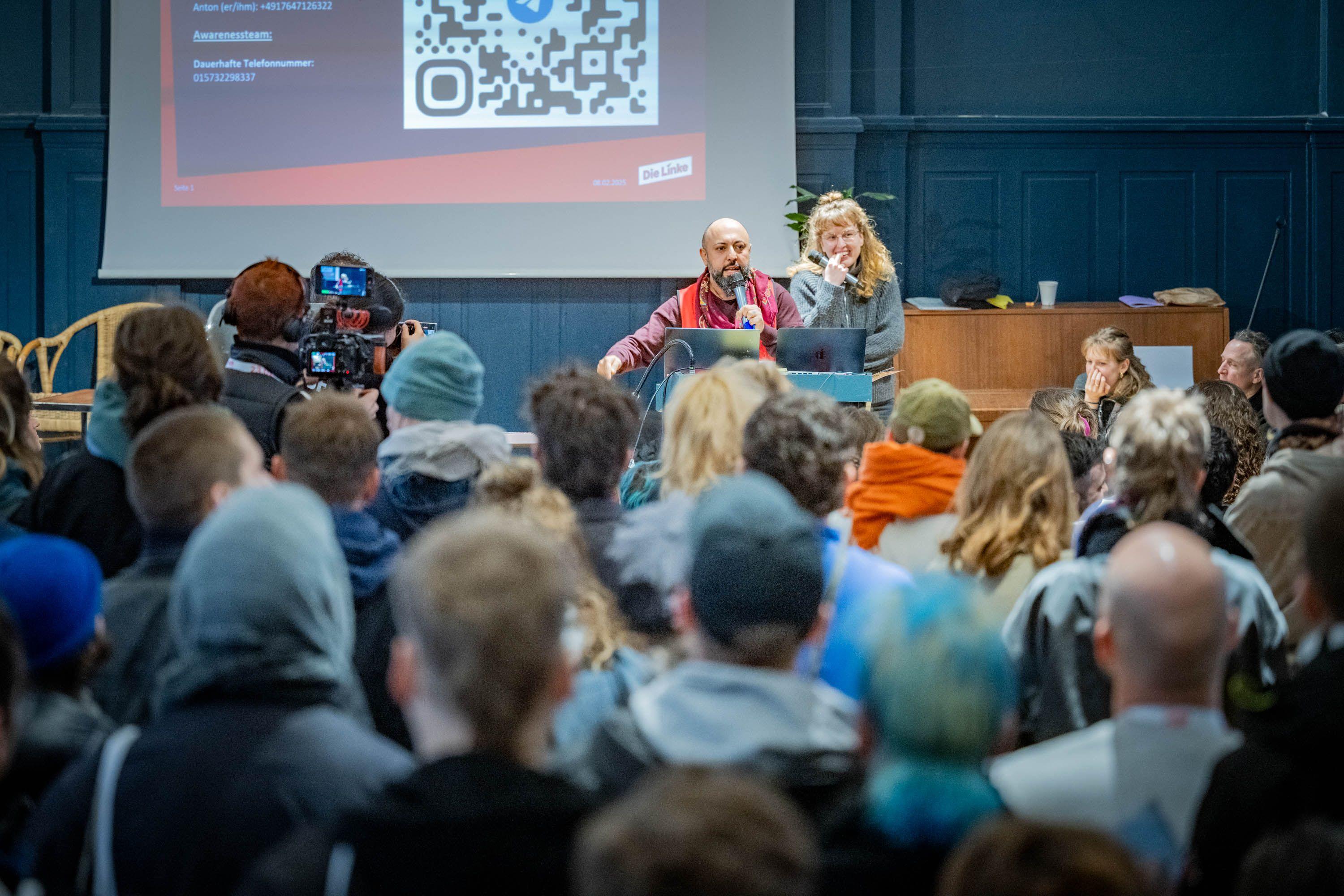 Als Direktkandidat Ferat Koçak seine Rede hält, ist der Saal proppenvoll, die Stimmung kämpferisch. (Foto: © Nici Wegener, 2025)