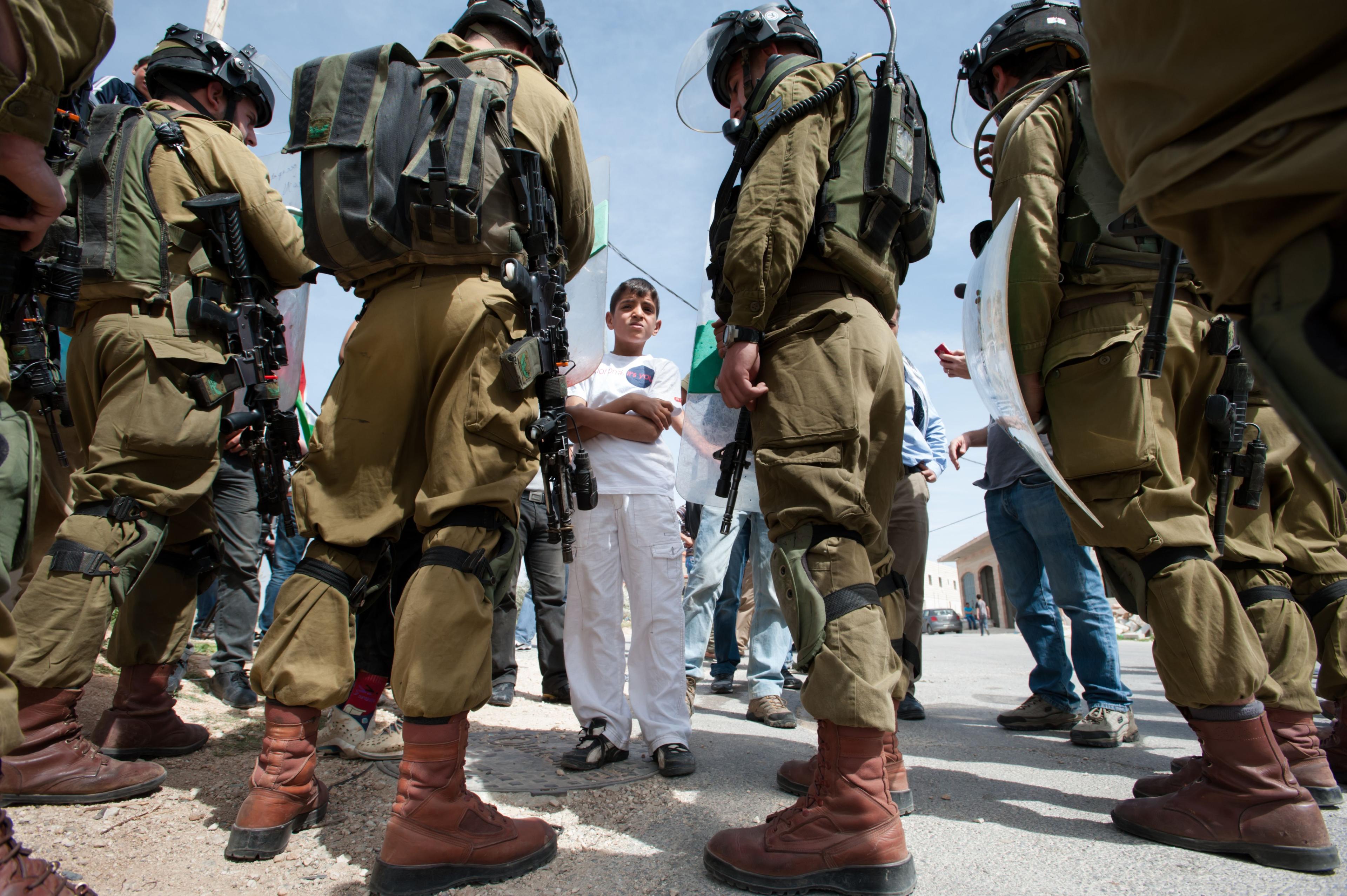 Ein palästinensischer Junge konfrontiert schwer bewaffnete israelische Soldaten während einer Demonstration im Dorf Al-Masara, Westjordanland, 15. März 2013.