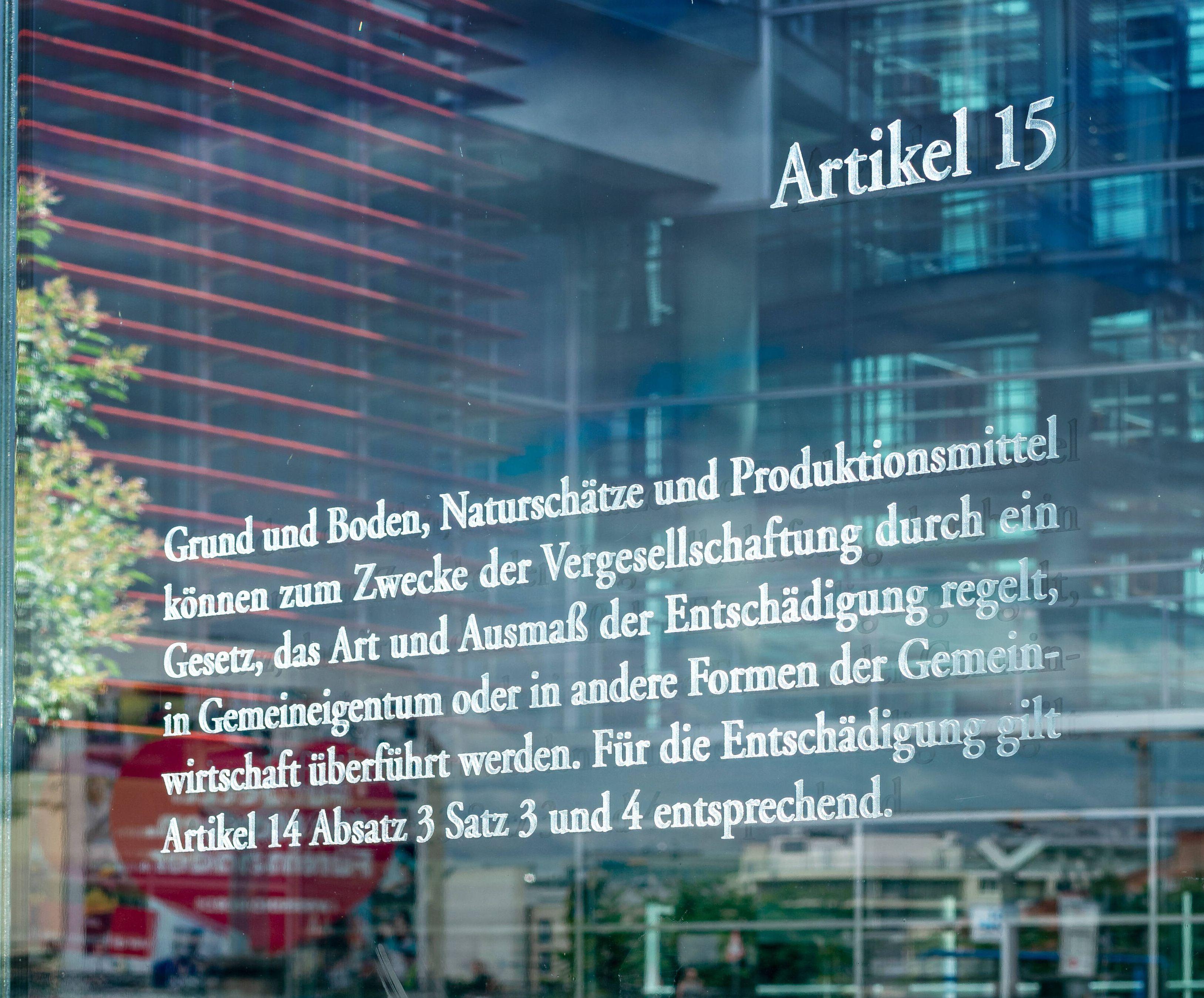 Artikel 15 GG auf einer Glastafel am Bundestag.