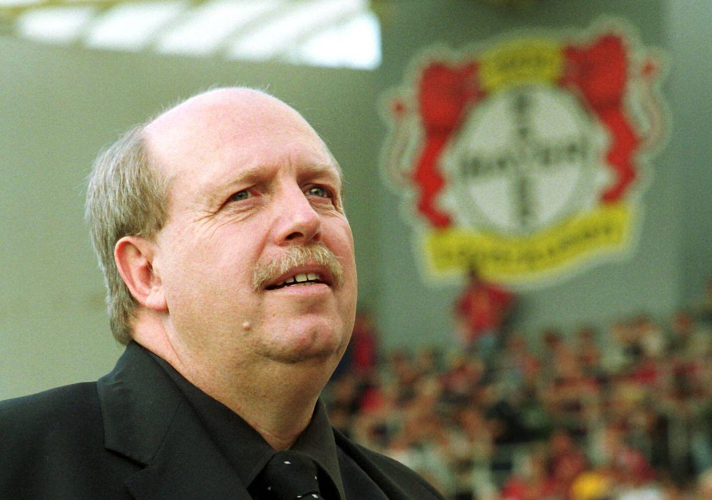 Manager-Legende Reiner Calmund vor dem Logo von Bayer Leverkusen.