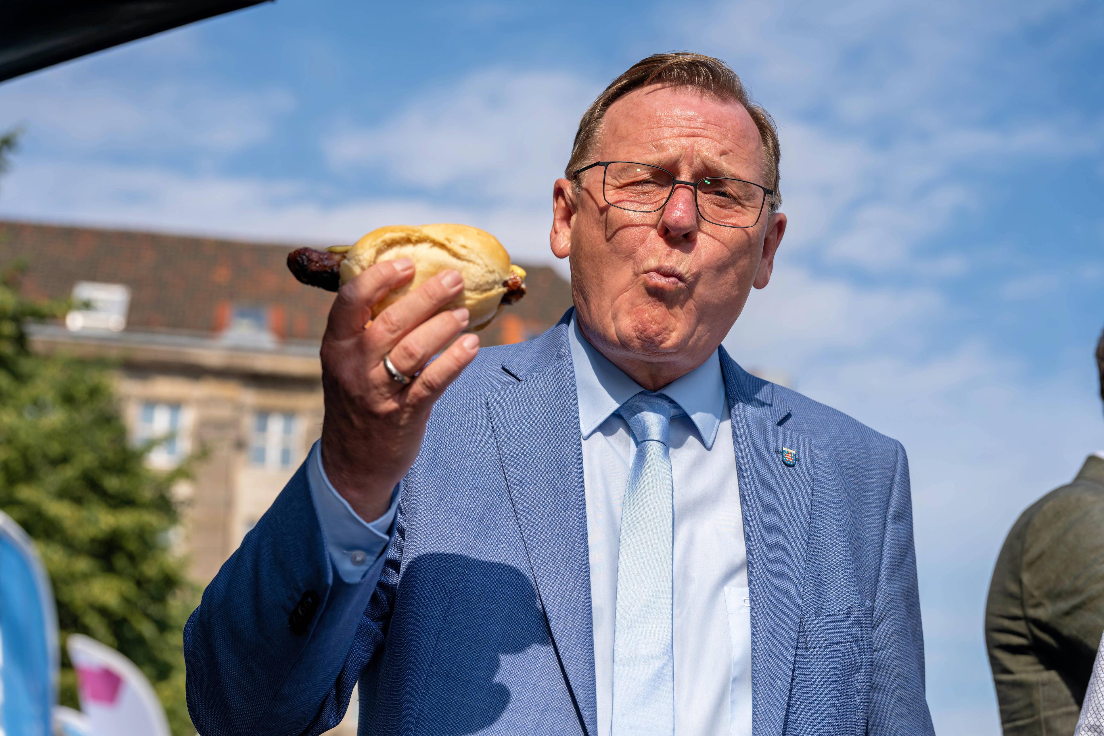 Ministerpräsident Bodo Ramelow genießt eine Bratwurst beim Sommerfest der Thüringer Landesvertretung in Berlin, 20. Juni 2023.