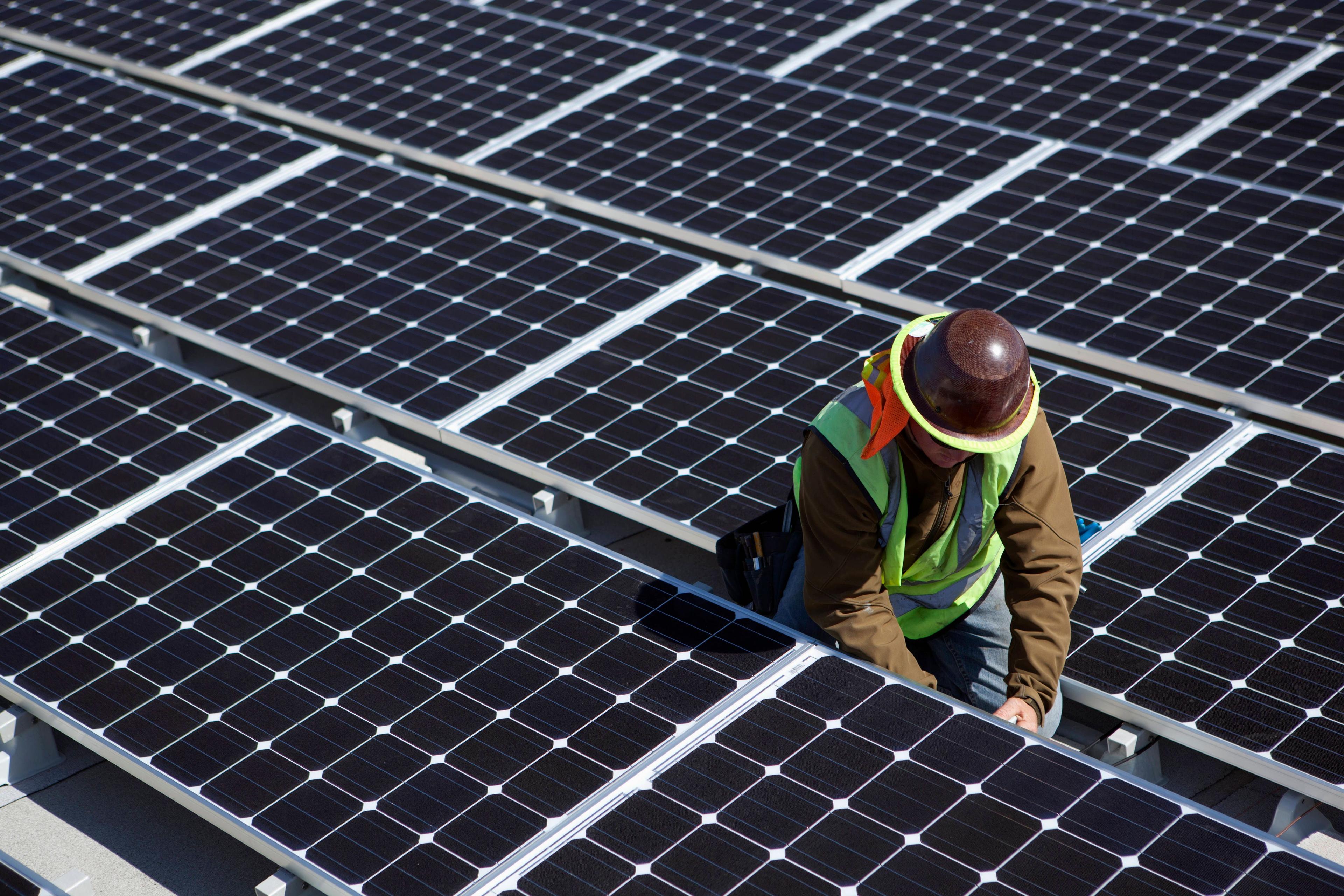 Arbeiter installiert Solarpanele.