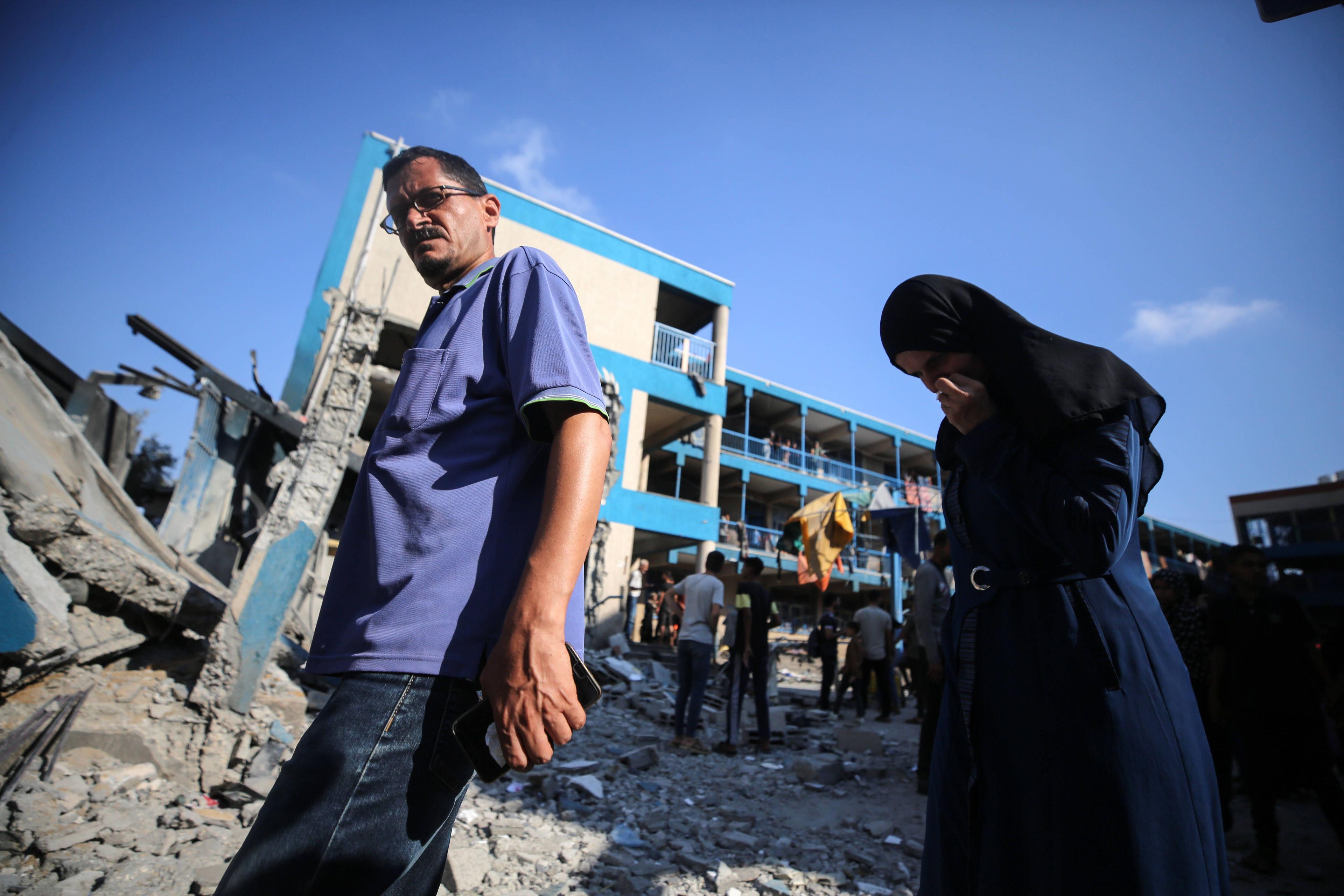 Menschen laufen durch die Trümmer einer von den Vereinten Nationen betriebenen Schule in Nuseirat, die von der israelischen Armee bombardiert wurde, 14. Juli 2024.