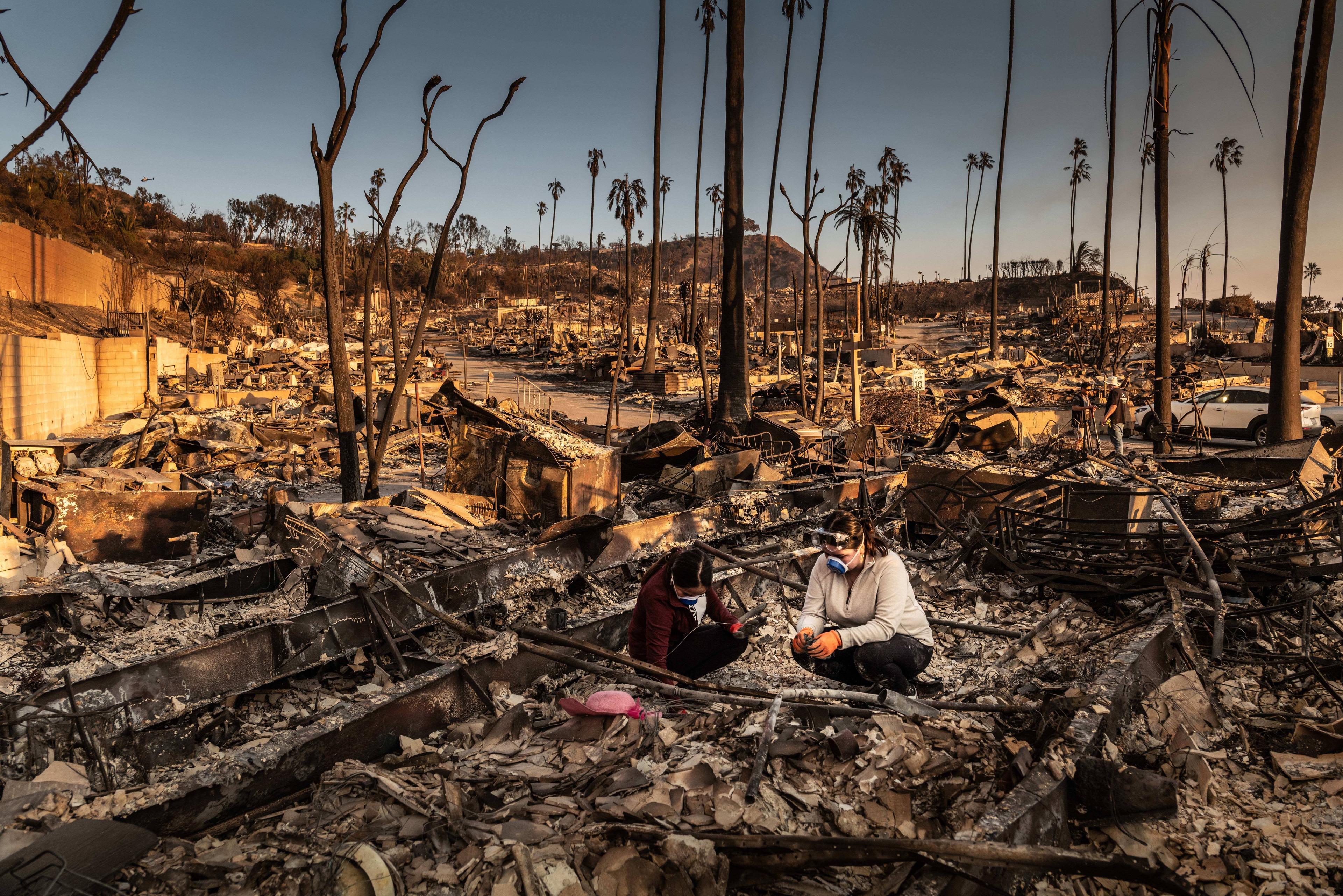 Betroffene der Brände zwischen den Ruinen ihres Hauses im Stadtteil Pacific Palisades von LA, 11. Januar 2024.