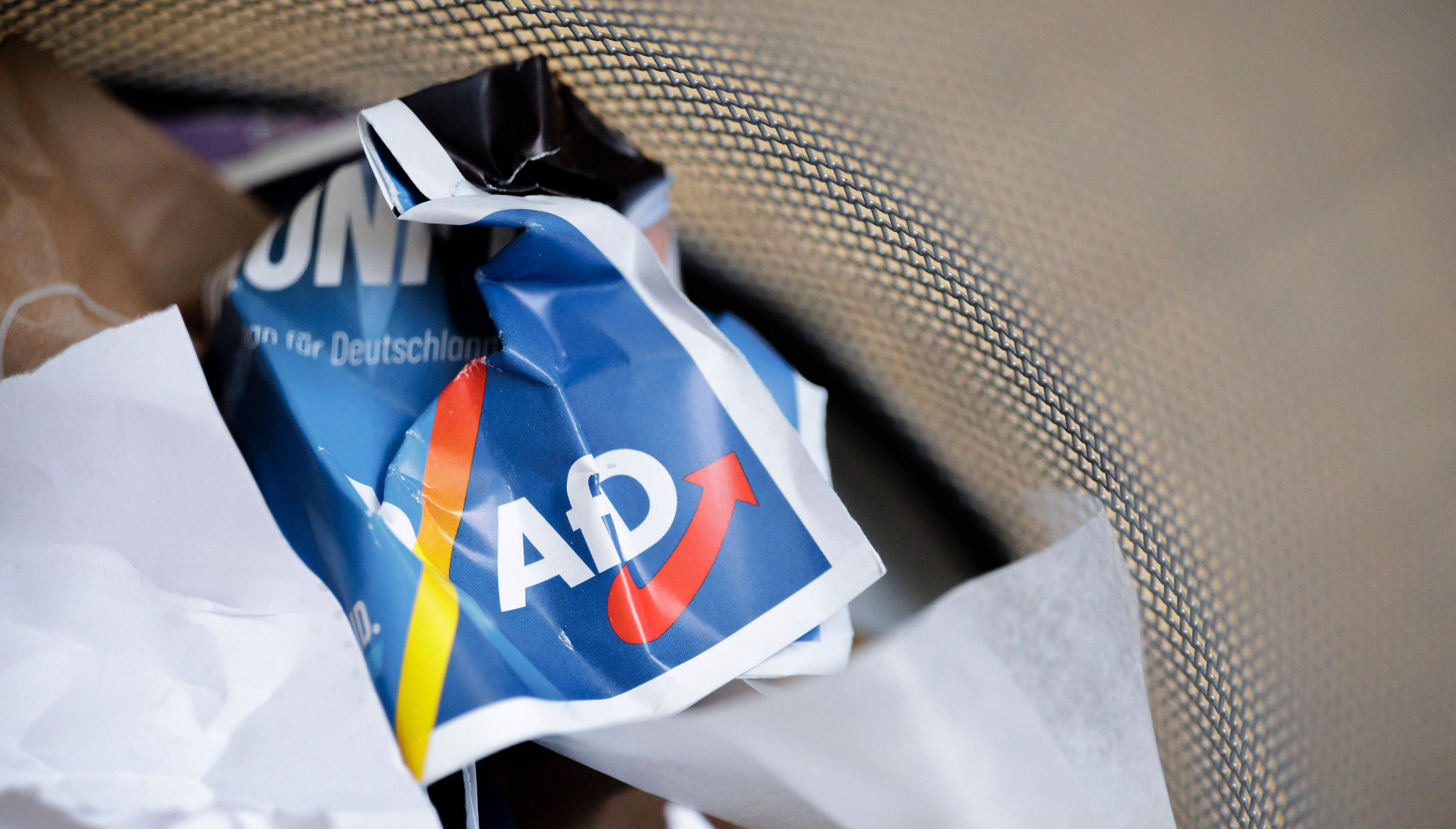 Kann weg: AfD-Plakat zerknüllt in einem Mülleimer.