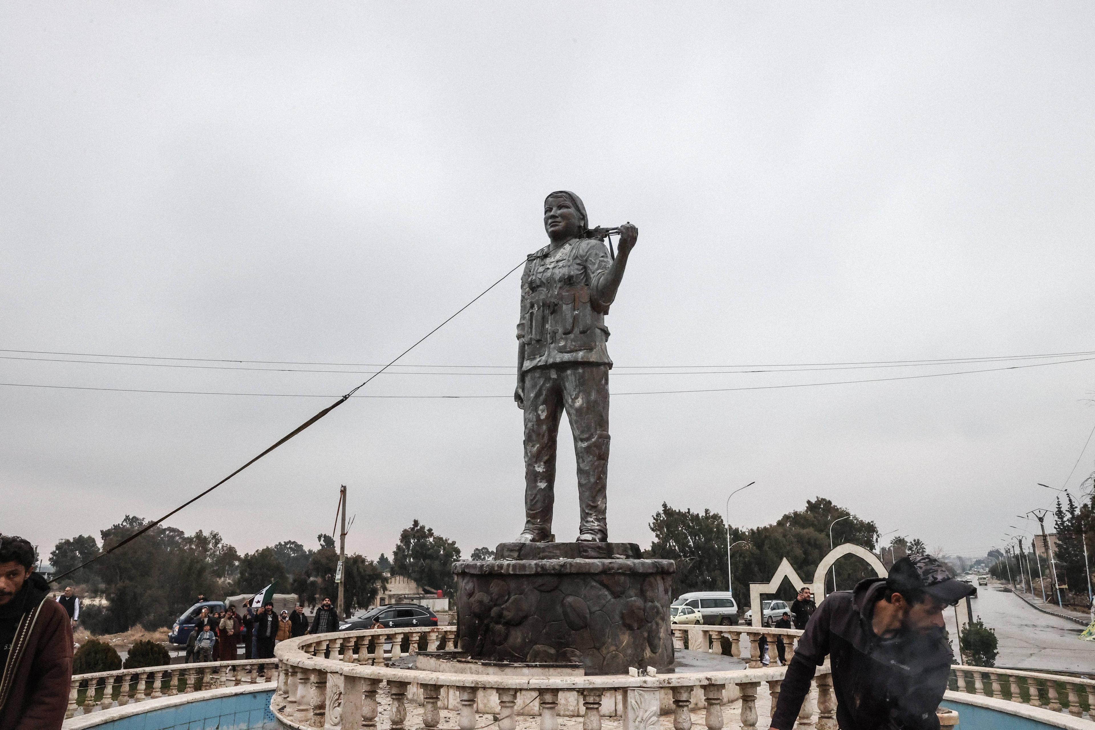 In Al-Tabqah wird die Statue einer YPG-Kämpferin niedergerissen.