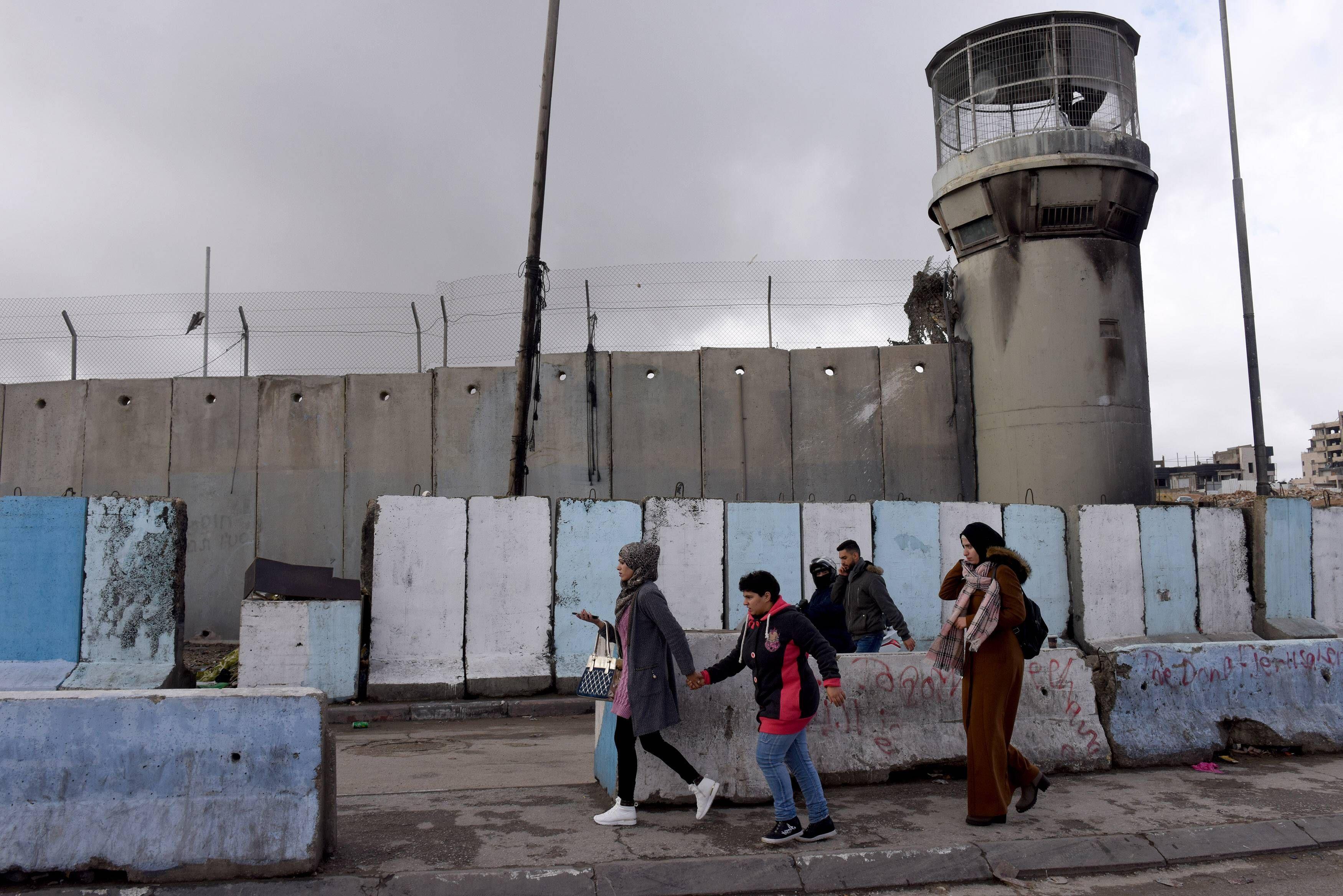 Palästinenserinnen und Palästinenser gehen an Absperrungen vorbei am Qalandiya-Checkpoint zwischen Jerusalem und Ramallah im Westjordanland, 17. Januar 2019.