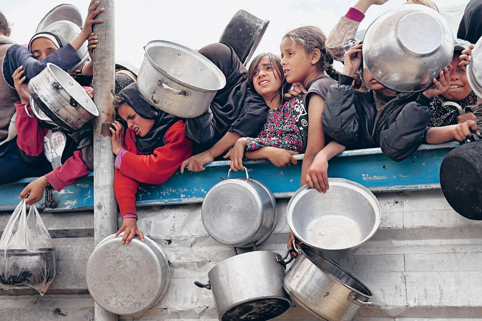 Palästinensische Kinder warten am 11. April 2025 in Khan Yunis auf Lebensmittel.