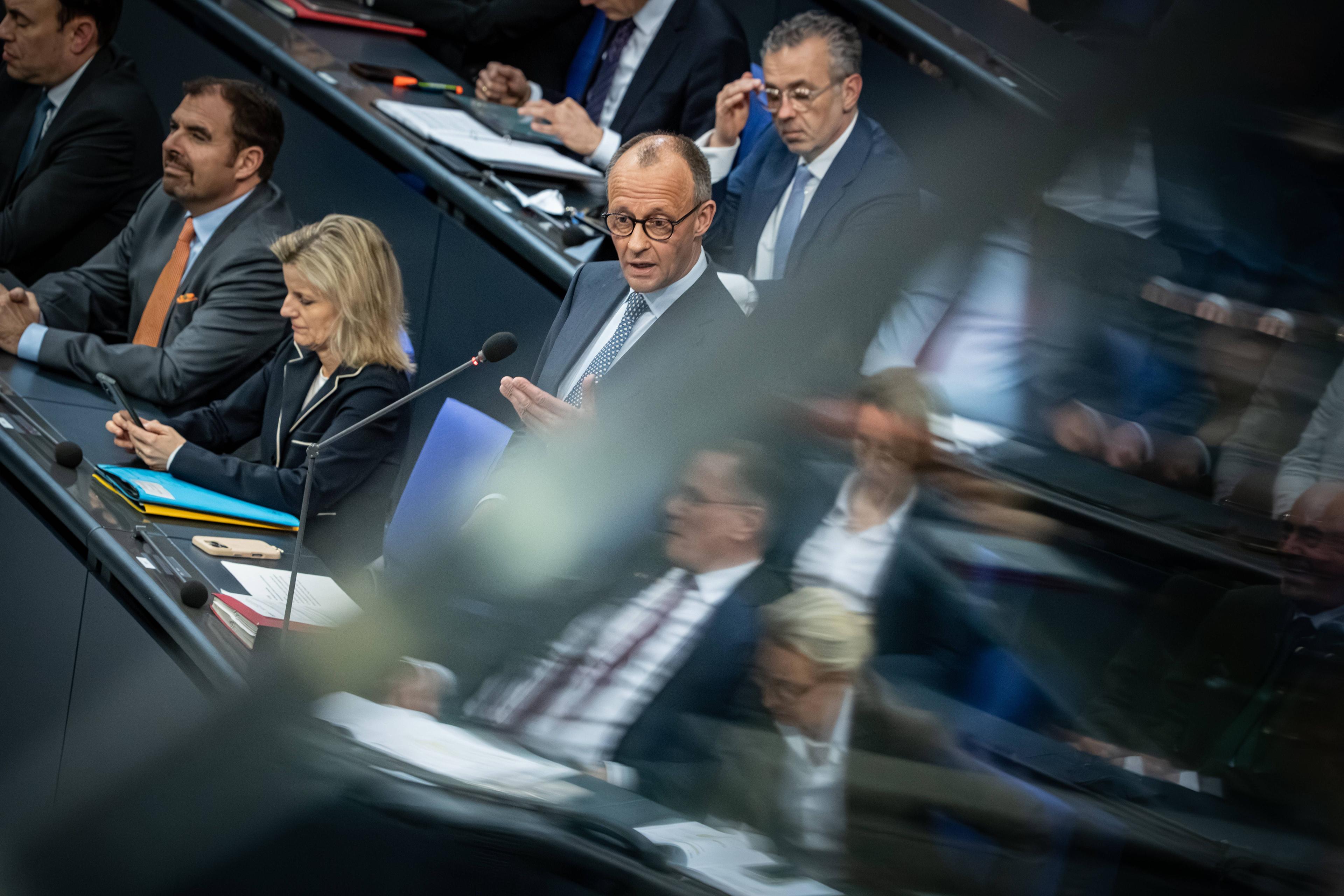 Friedrich Merz im Bundestag, in einer Spiegelung Tino Chrupalla, Alice Weidel und Beatrix von Storch.