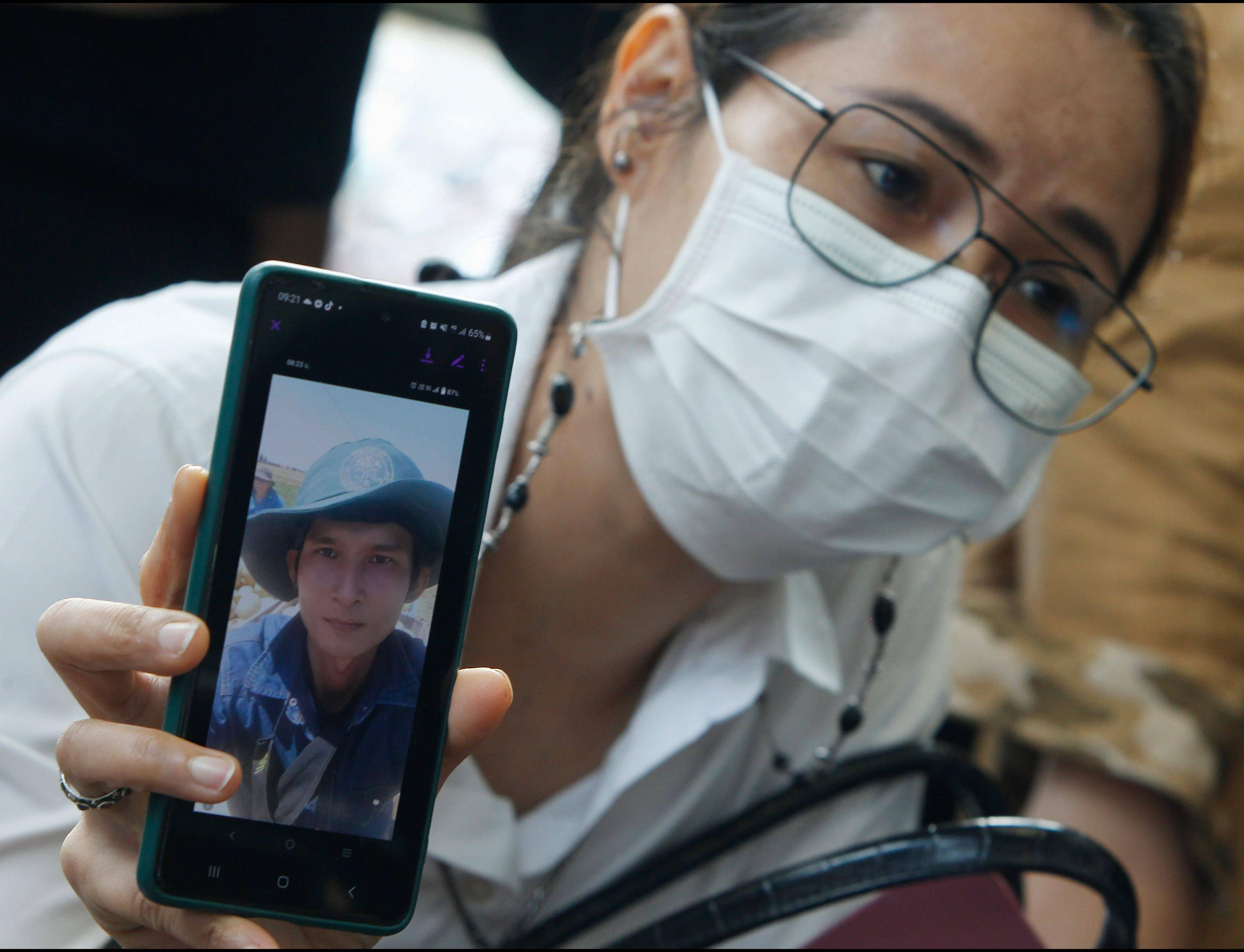 Wongduien Lumlert hält ein Handy mit einem Bild ihres Verwandten Anan Phetkaew, eines thailändischen Arbeiters, der bei dem Hamas-Anschlag am 7. Oktober getötet wurde.