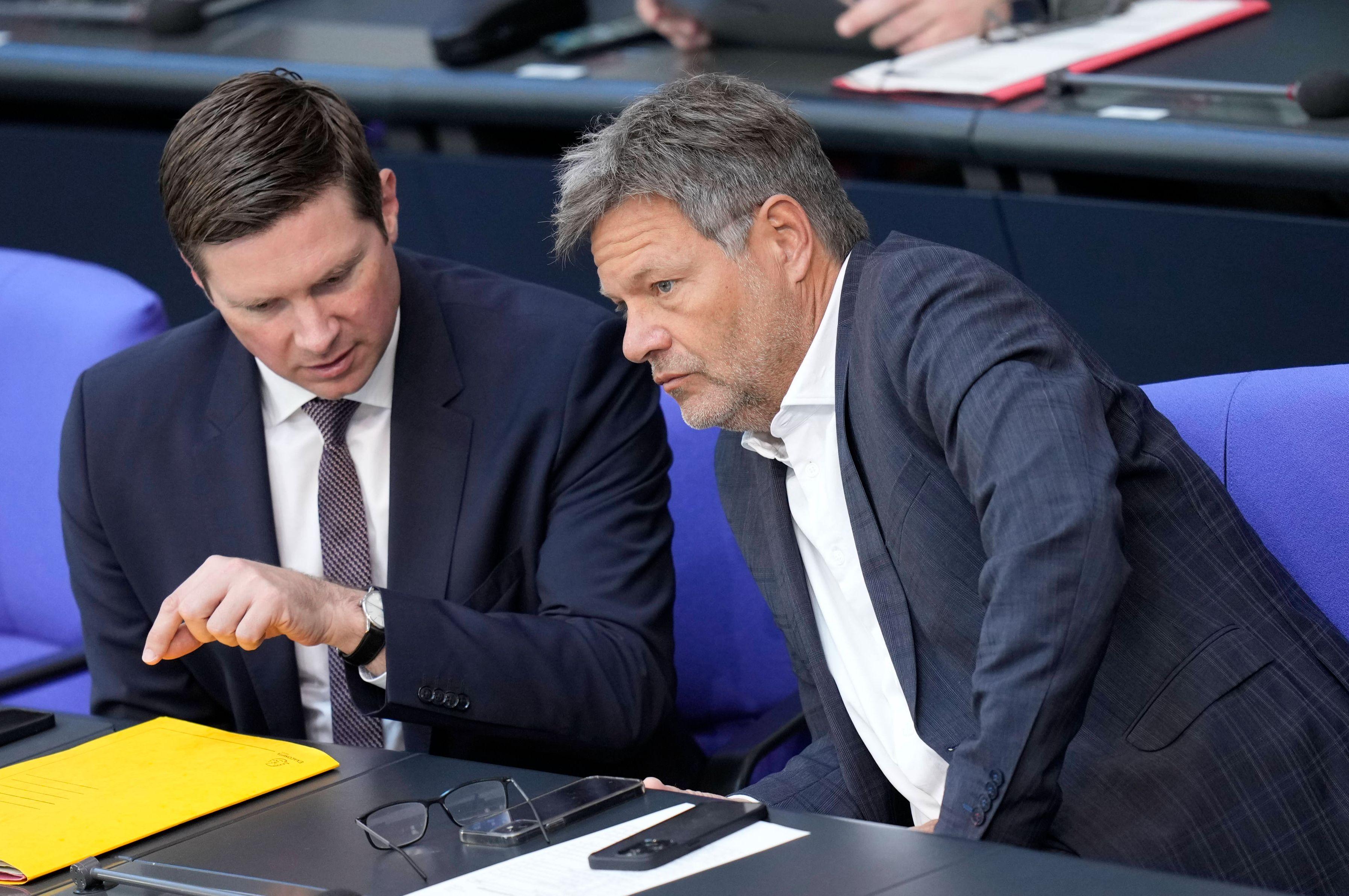 FDP-Staatssekretär Florian Toncar zeigt Robert Habeck seine gelbe Mappe. Dieser ist wenig begeistert.