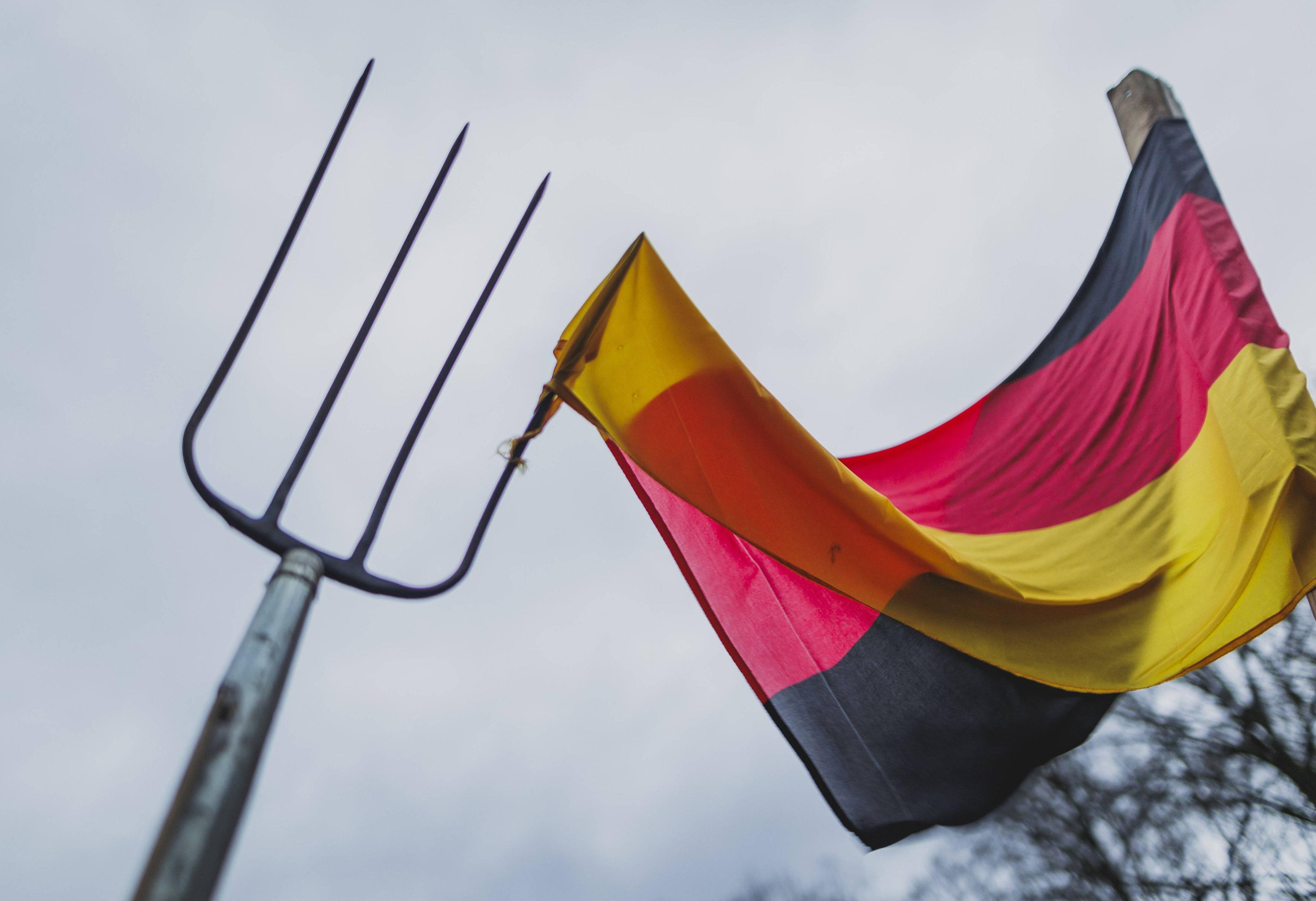 Eine Mistgabel sticht in eine Deutschland-Flagge auf dem Bauern-Protest in Berlin am 15. Januar 2024.